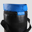 Black insulated lunch bag with blue top section on a light gray background