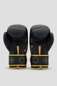 Palm-side view of black and gold DAAN boxing gloves showing inner padding and reinforced wrist straps.