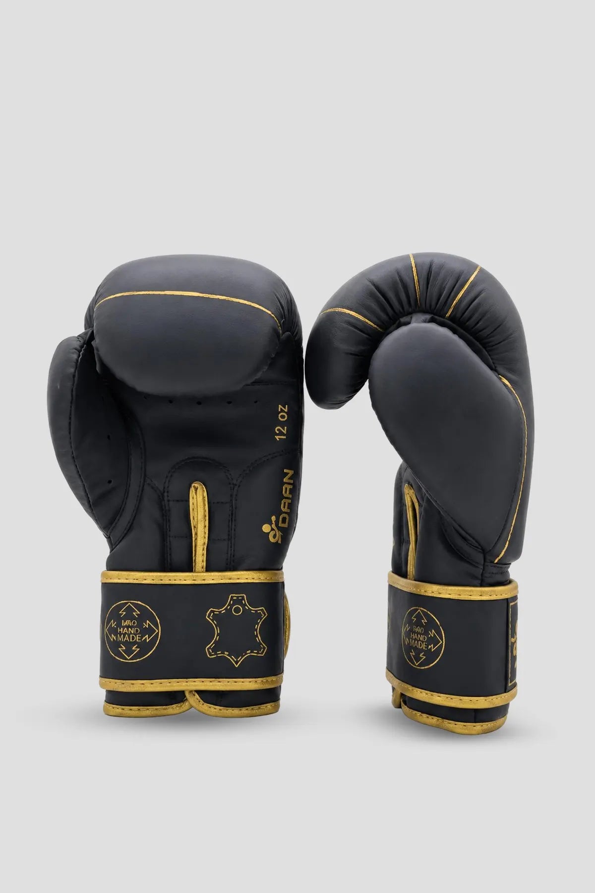 Black and gold DAAN boxing gloves displayed from palm and side angles for training and bag work.