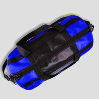 Blue duffel bag with black straps on a light gray background