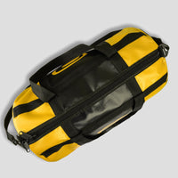 Yellow duffel bag with black straps on a light gray background