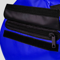 Close-up of a blue bag with a black zipper and strap.