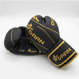 DAAN Apex matt black boxing gloves, angled pair with gold DAAN branding